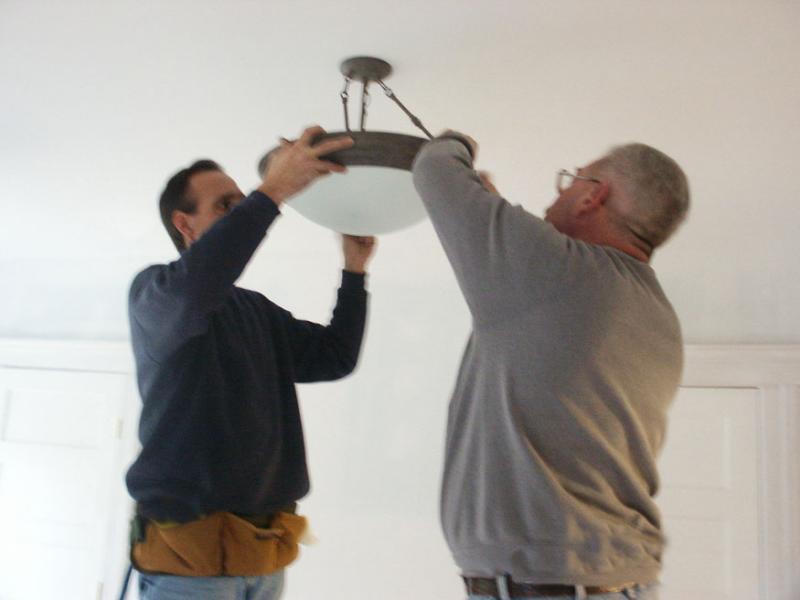 electricians replacing a light fixture